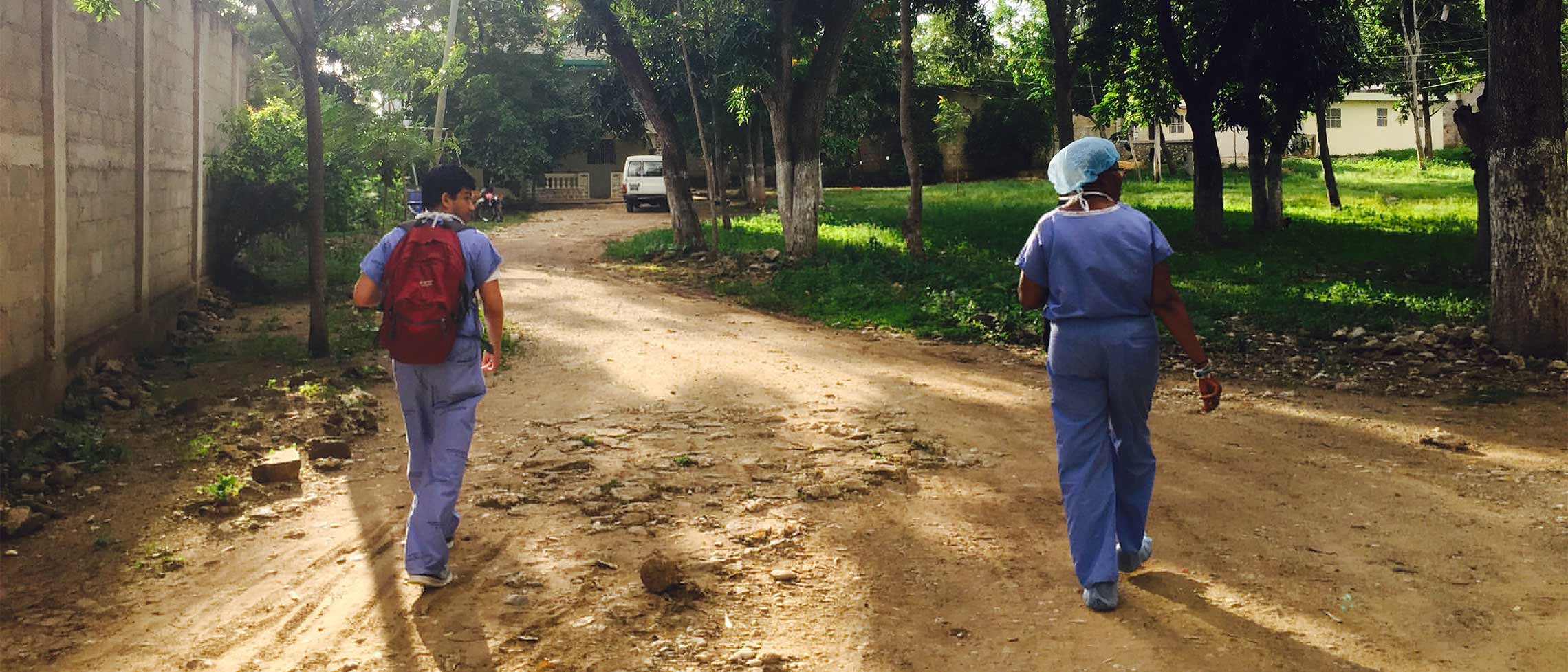 An Emory medical student and nurse walk home from the hospital. Elizabeth Carter, SOM. Haiti.