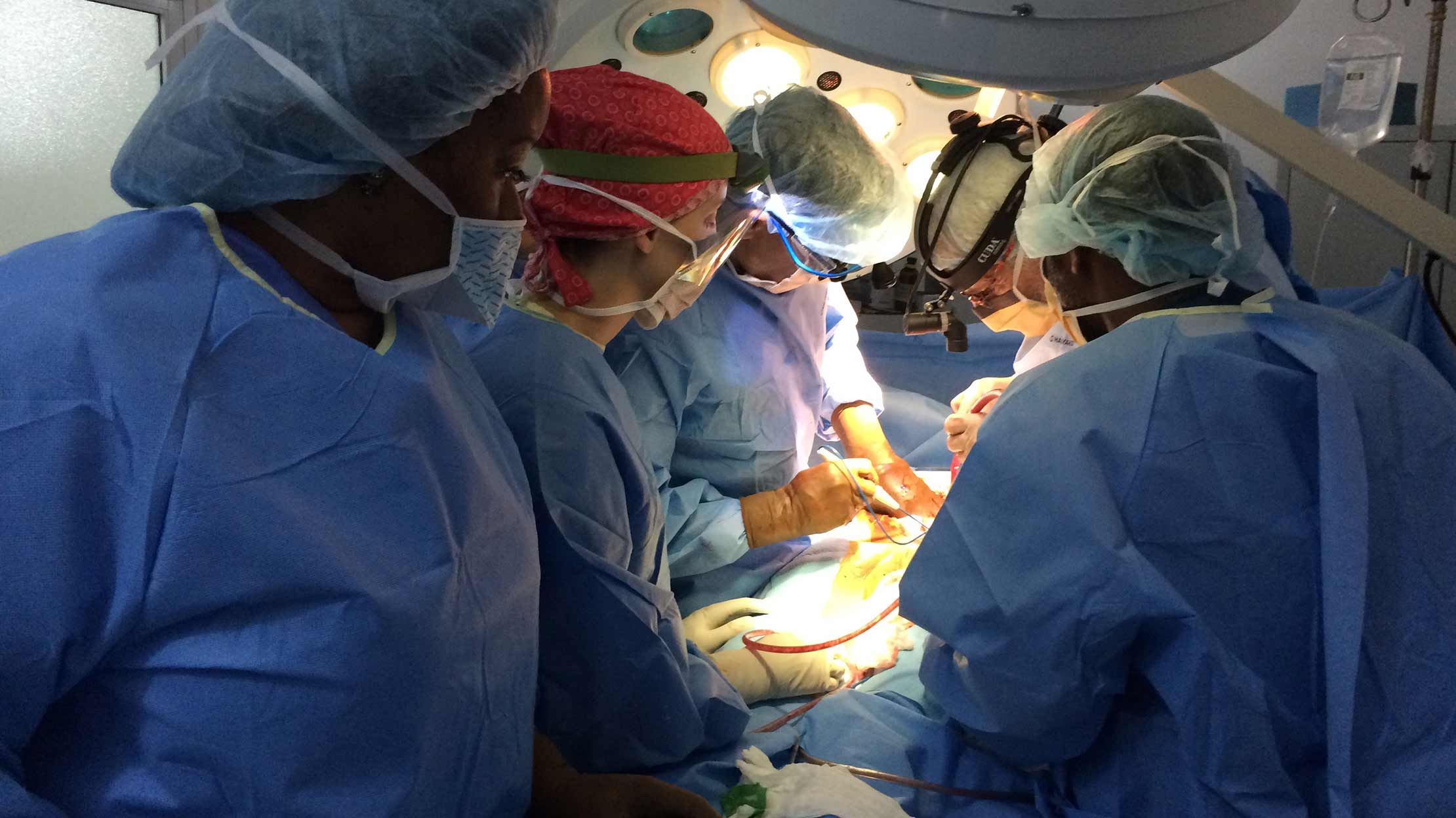 Emory faculty and staff demonstrate surgical techniques for an Emory medical student and a Haitian physician. 
